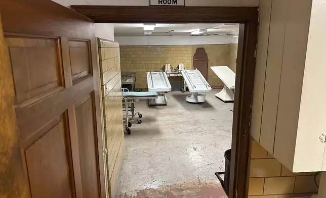 A sign above the doorway indicates it is the entrance to the autopsy room in the basement of Mortuary Manor, a former funeral home that has become a museum and host to paranormal investigations Wednesday, Sept. 30, 2026, in Toledo, Ohio (AP Photo/Mike Householder)