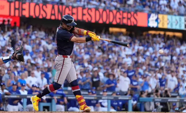 Atlanta Braves' Mauricio Dubón hits an RBI single during the first inning of Game 2 of a National League Division Series baseball game against the Los Angeles Dodgers Sunday, Oct. 4, 2026, in Los Angeles. (AP Photo/Mark J. Terrill)