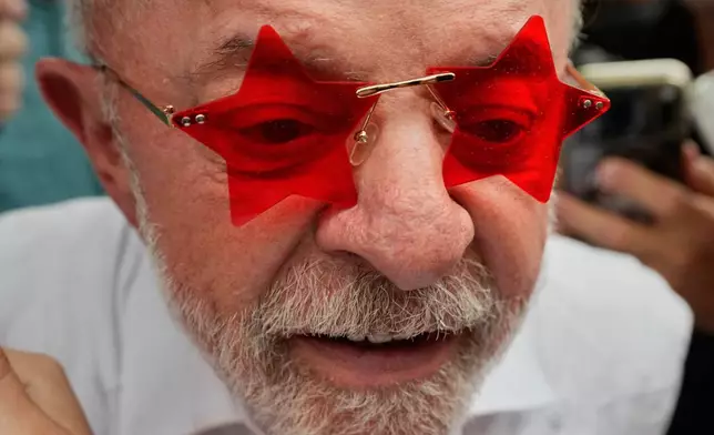 President Luiz Inacio Lula da Silva, who is seeking reelection, wears glasses given to him by a supporter after voting in the presidential runoff in Sao Bernardo do Campo, Brazil, Sunday, Oct. 25, 2026. (AP Photo/Natacha Pisarenko)