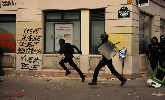 A police officer chases a protester during scuffles following a demonstration against under-resourced schools, in Paris, Tuesday, Oct. 6, 2026. (AP Photo/Teresa Suarez)