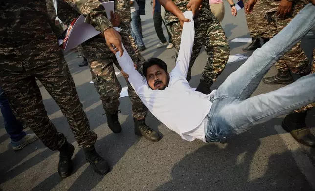 Security personnel detain an activist from the student wing of the Congress party during a youth protest calling for the resignation of the country's election chief Gyanesh Kumar, in New Delhi, India, Tuesday, Oct. 13, 2026. (AP Photo/Prabhat Mehrotra)