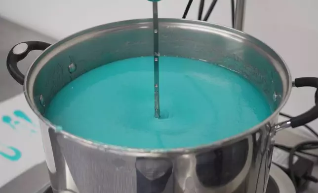 A mixer stirs a batch of blueberry lemonade gummies in a heated pot at the Deutermann Farms kitchen in Clayton, N.C., on Wednesday, Sept. 23, 2026. (AP Photo/Allen G. Breed)