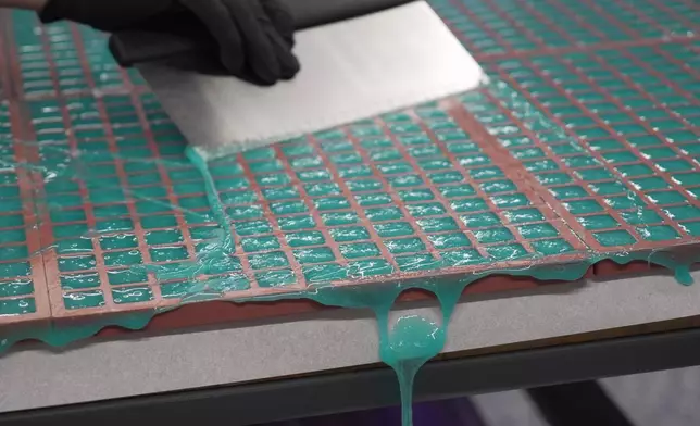 Hot gummy mixture drips off the table's edge as Nicholas Hohns uses a pastry knife to fill mold at his Deutermann Farms kitchen in Clayton, N.C., on Wednesday, Sept. 23, 2026. (AP Photo/Allen G. Breed)