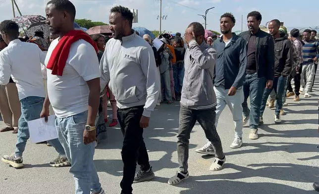 In this photo made with a smartphone, former Tigrayan fighters line up for a disarmament, demobilization and reintegration program in Mekelle, Ethiopia, Thursday, Oct. 15, 2026. The program, overseen by Ethiopia's National Rehabilitation Commission, is part of the 2022 Pretoria peace agreement, which renewed fighting has effectively shattered. (AP Photo/Filmon Equar Hailu)