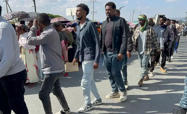 In this photo made with a smartphone, former Tigrayan fighters line up to register for a disarmament, demobilization and reintegration program in Mekelle, Ethiopia, Thursday, Oct. 15, 2026. The resumed registration comes as Ethiopia's government establishes a six-month caretaker administration for Tigray following renewed fighting. (AP Photo/Filmon Equar Hailu)