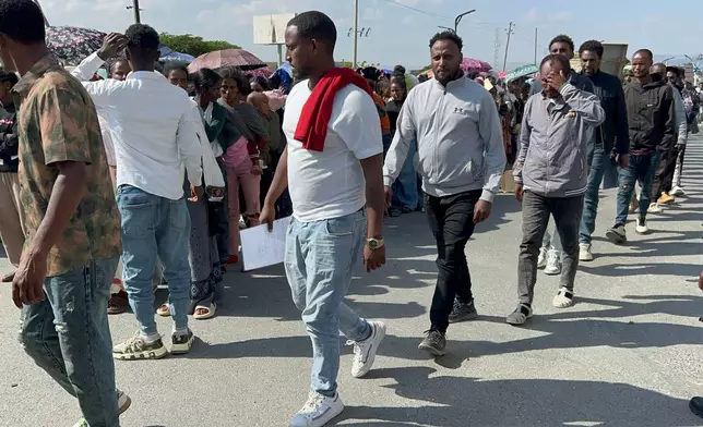 In this photo made with a smartphone, former Tigrayan fighters wait in line to register for a disarmament, demobilization and reintegration program in Mekelle, Ethiopia, Thursday, Oct. 15, 2026. Registration has resumed following renewed fighting in the northern Ethiopian region. (AP Photo/Filmon Equar Hailu)