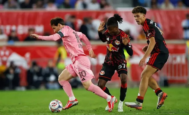 Inter Miami forward Lionel Messi, left, dribbles as New York Red Bulls forward Mohammed Sofo, center, and Adri Mehmeti defend during an MLS soccer match Saturday, Oct. 24, 2026, in Harrison, N.J. (AP Photo/Eduardo Munoz Alvarez)