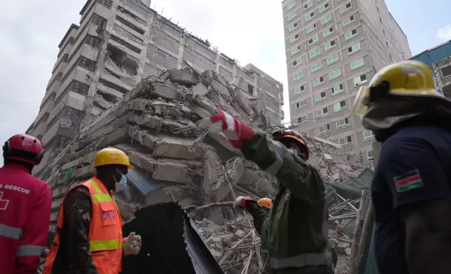 Security forces and civil defense work after a multi-story building collapsed in Nairobi, Kenya, Friday, Oct. 23, 2026. (AP Photo/Brian Inganga)