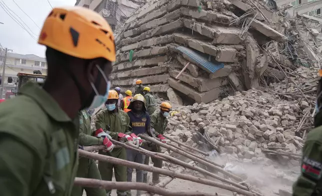 Security forces and civil defense work after a multi-story building collapsed in Nairobi, Kenya, Friday, Oct. 23, 2026. (AP Photo/Brian Inganga)
