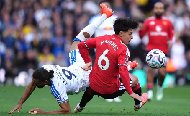 Manchester United's Lisandro Martinez, right, and Leeds United's Dominic Calvert-Lewin battle for the ball during the English Premier League soccer match between Leeds United and Manchester United in Leeds, England, Sunday, Oct. 18, 2026. (Annabel Lee-Ellis/PA via AP)