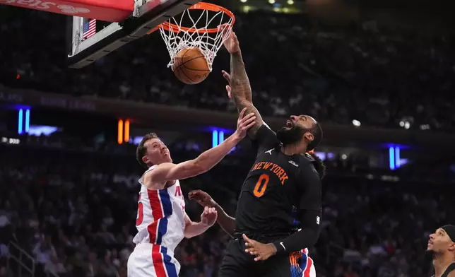 New York Knicks' Andre Drummond, right, dunks the ball in front of Detroit Pistons' Duncan Robinson during the first half of an NBA basketball game Tuesday, Oct. 27, 2026, in New York. (AP Photo/Frank Franklin II)