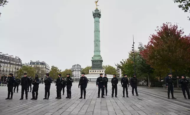 Police officers patrol the empty Place de la Bastille ahead of a demonstration against rising living costs in Paris, Saturday, Oct. 24, 2026. (AP Photo/Emma Da Silva)
