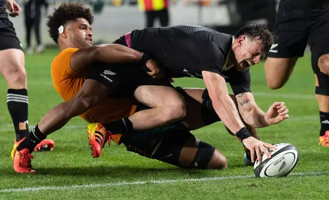 New Zealand's Leroy Carter, scores a try as Australia's Rob Valetini tackles him during a Bledisloe Cup rugby union test match in Auckland, New Zealand on Saturday, Oct. 10, 2026. (Brett Phibbs/Photosport via AP)