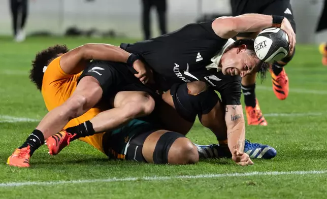 New Zealand's Leroy Carter, scores a try as Australia's Rob Valetini tackles him during a Bledisloe Cup rugby union test match in Auckland, New Zealand on Saturday, Oct. 10, 2026. (Brett Phibbs/Photosport via AP)