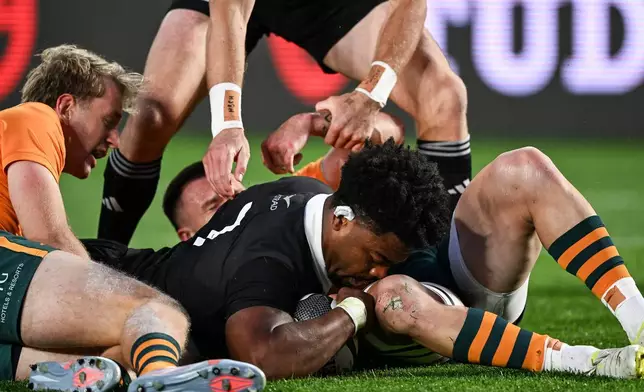New Zealand's Peter Lakai, center, scores a try as Australia's Max Jorgensen, left, can't hold him up in a Bledisloe Cup rugby union test match in Auckland, New Zealand on Saturday, Oct. 10 2026. (Andrew Cornaga/Photosport via AP)