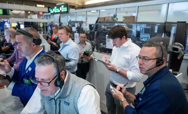 Options traders, including Marty Handler, foreground, and Matt Hefter, right, work on the floor of the New York Stock Exchange, Thursday, Oct. 8, 2026, in New York. (AP Photo/Yuki Iwamura)