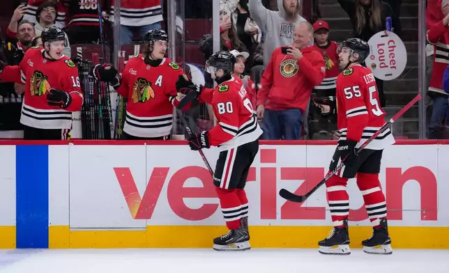 Chicago Blackhawks right wing Roman Kantserov (80) celebrates his second goal of the night with teammates during the second period of an NHL hockey game against the Pittsburgh Penguins, Tuesday, Oct. 13, 2026, in Chicago. (AP Photo/Harry Figiel)