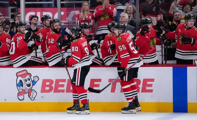 Chicago Blackhawks right wing Roman Kantserov (80) celebrates his second goal of the night with teammates during the second period of an NHL hockey game against the Pittsburgh Penguins, Tuesday, Oct. 13, 2026, in Chicago. (AP Photo/Harry Figiel)