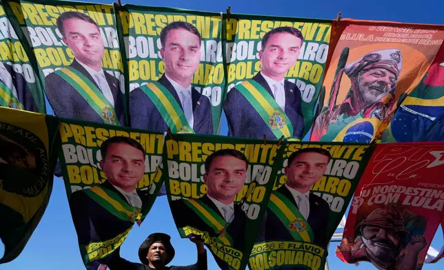 A street vendor sells campaign flags of presidential candidates Sen. Flavio Bolsonaro and current President Luiz Inacio Lula da Silva who is running for reelection in Brasilia, Brazil, Tuesday, Sept. 29, 2026. (AP Photo/Eraldo Peres)