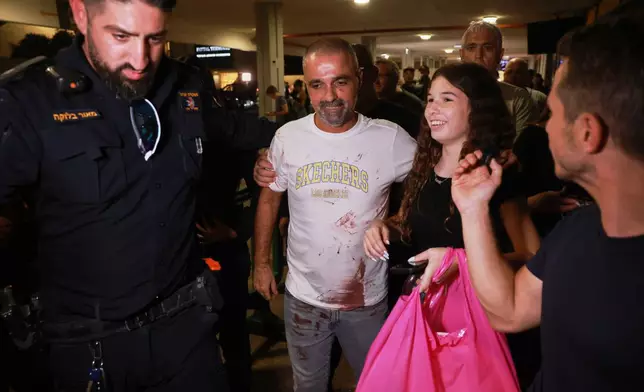 Israeli passenger Yaniv Hayoun, with blood stains on his shirt, who was aboard a Flydubai aircraft that made an emergency landing in Saudi Arabia, is welcomed at the arrivals gate at Ben Gurion International Airport near Tel Aviv, Israel, Wednesday, Sept. 30, 2026. (AP Photo/Tomer Appelbaum)