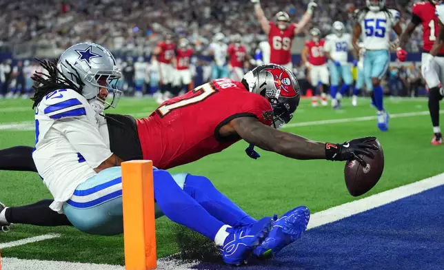 Tampa Bay Buccaneers running back Bucky Irving (7) dives past Dallas Cowboys defensive back Reddy Steward (27) for a touchdown in the first half of an NFL football game in Arlington, Texas on Thursday, Oct. 8, 2026. (AP Photo/Julio Cortez)