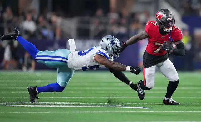 Tampa Bay Buccaneers running back Bucky Irving (7) gets past Dallas Cowboys linebacker Dee Winters (53) in the second half of an NFL football game in Arlington, Texas on Thursday, Oct. 8, 2026. (AP Photo/Julio Cortez)