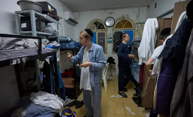 Ultra-Orthodox Jewish seminary students get ready for bed in their room at Ponevezh, Israel’s most prominent yeshiva, or seminary, in Bnei Brak, Israel, Tuesday, June 30, 2026. (AP Photo/Ohad Zwigenberg)