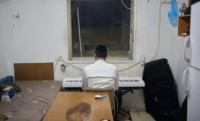 An Ultra-Orthodox Jewish seminary student plays an electronic keyboard in his room at Ponevezh, Israel’s most prominent yeshiva, or seminary, in Bnei Brak, Israel, Monday, May 11, 2026. (AP Photo/Ohad Zwigenberg)