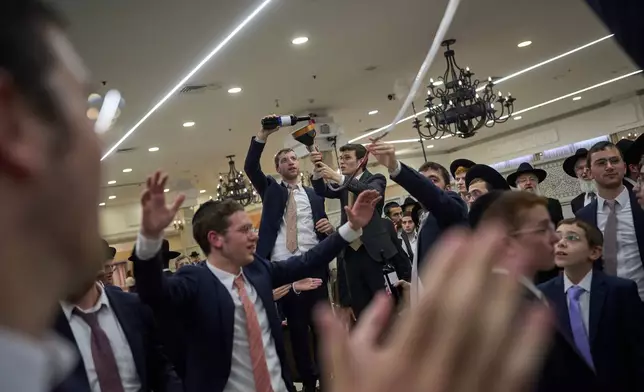 Ultra-Orthodox Jewish seminary students celebrate during the wedding of a fellow student at a wedding hall in Jerusalem, Thursday, June 11, 2026. (AP Photo/Ohad Zwigenberg)