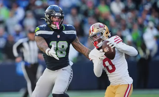 San Francisco 49ers cornerback Renardo Green (0) intercepts a pass intended for Seattle Seahawks tight end Elijah Arroyo (18) during the second half of an NFL football game Sunday, Oct. 11, 2026, in Seattle. (AP Photo/Lindsey Wasson)