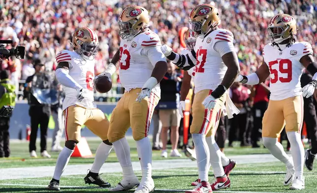 San Francisco 49ers defensive tackle Gracen Halton, second from left, reacts with Malik Mustapha (6), Khalid Kareem (47), Ogbo Okoronkwo (59) after recovering a fumble by Seattle Seahawks running back George Holani during the first half of an NFL football game Sunday, Oct. 11, 2026, in Seattle. (AP Photo/Lindsey Wasson)