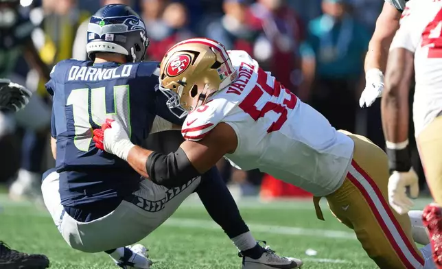 San Francisco 49ers defensive tackle Sebastian Valdez (55) sacks Seattle Seahawks quarterback Sam Darnold (14) during the first half of an NFL football game Sunday, Oct. 11, 2026, in Seattle. (AP Photo/Lindsey Wasson)