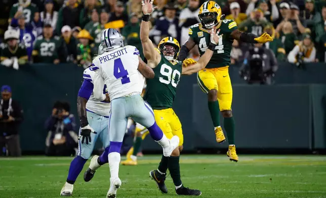 Green Bay Packers' Lukas van Ness and Zaire Franklin leap as they help stop Dallas Cowboys' Dak Prescott on a forth down play during the second half of an NFL football game in Green Bay, Wis., Sunday, Oct. 18, 2026. (AP Photo/Mike Roemer)