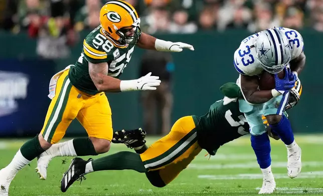Dallas Cowboys' Javonte Williams is stopped by Green Bay Packers' Evan Williams during the first half of an NFL football game in Green Bay, Wis., Sunday, Oct. 18, 2026. (AP Photo/Nam Huh)