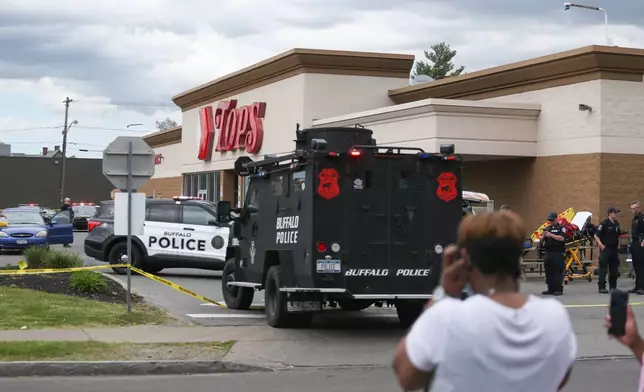 FILE - A crowd gathers as police investigate after a shooting at a supermarket on May 14, 2022, in Buffalo, N.Y. (AP Photo/Joshua Bessex, File)