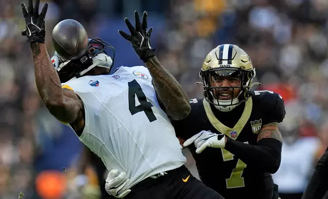 Pittsburgh Steelers wide receiver Dk Metcalf (4) catches the ball as New Orleans Saints safety Jonas Sanker (7) challenges during an NFL football game in Saint-Denis, outside Paris, Sunday, Oct. 25, 2026. (AP Photo/Steve Luciano)