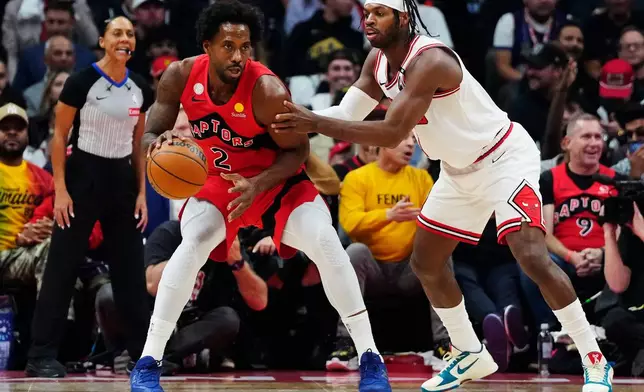 Toronto Raptors' Kawhi Leonard (2) protects the ball from Chicago Bulls' Buddy Hield (7) during the first half of an NBA basketball game in Toronto, Wednesday, Oct. 21, 2026. (Frank Gunn/The Canadian Press via AP)