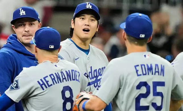 Los Angeles Dodgers' Shohei Ohtani, center, Enrique Hernández (8) and Tommy Edman (25) celebrate the team's win in Game 3 of baseball's National League Division Series against the Atlanta Braves, Tuesday, Oct. 6, 2026, in Atlanta. (AP Photo/Brynn Anderson)
