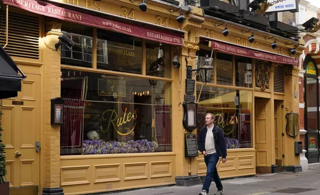 A man walks past London's oldest Restaurant ' Rules' which has been donated to Europe's biggest conservation charity in London, Wednesday, Oct. 14, 2026.(AP Photo/Alberto Pezzali)