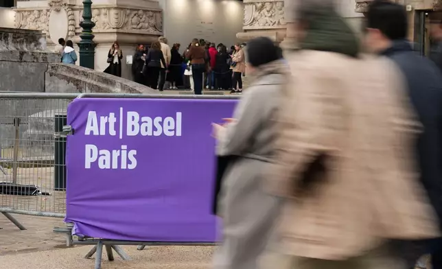 People walk past the Paris' Grand Palais hosting Art Basel art fair, Friday, Oct. 23, 2026 after planned anti-government protests prompted organizers to cancel their weekend program. (AP Photo/Teresa Suarez)