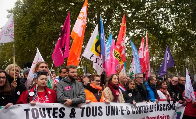 Leftists unions and political parties members hold a banner reading "all united against fascism. For the popular rally and social progress" during a protest on the sidelines of the far-right party Rassemblement National (RN) congress, in Orleans, France, Saturday, Oct. 24, 2026. (AP Photo/Teresa Suarez)