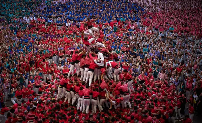 Members of Castellers Joves de Valls fall as they tried to form a "castell," or human tower, during the 30th Concurs de Castells, or Human Tower Competition in Tarragona, Spain, Sunday, Oct. 4, 2026. (AP Photo/Emilio Morenatti)