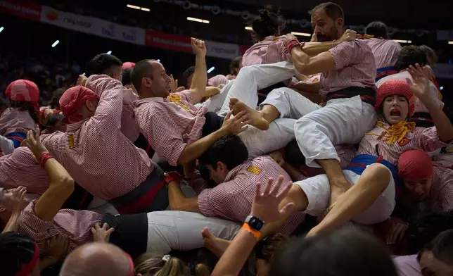 Members of Castellers Xiquets de Tarragona fall as they tried to form a "castell," or human tower, during the 30th Concurs de Castells, or Human Tower Competition in Tarragona, Spain, Sunday, Oct. 4, 2026. (AP Photo/Emilio Morenatti)