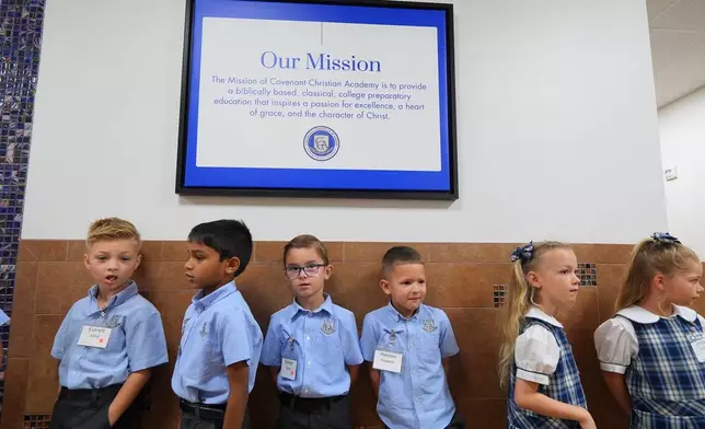 Elementary school students at Covenant Christian Academy line a hallway in Colleyville, Texas, Wednesday, Aug. 12, 2026. (AP Photo/LM Otero)