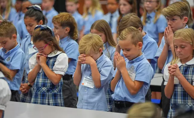 Children at Covenant Christian Academy pray during chapel at the private school in Colleyville, Texas, Wednesday, Aug. 12, 2026. (AP Photo/LM Otero)