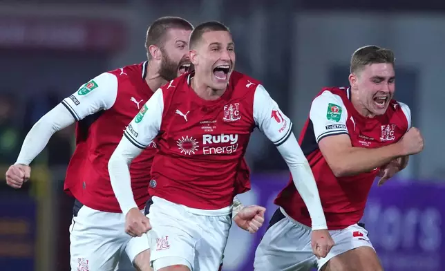 Fleetwood's players celebrate after winning a penalty shootout during the English League Cup soccer match between Fleetwood Town and Arsenal in Fleetwood, England, Tuesday, Oct. 27, 2026. (AP Photo/Ian Hodgson)
