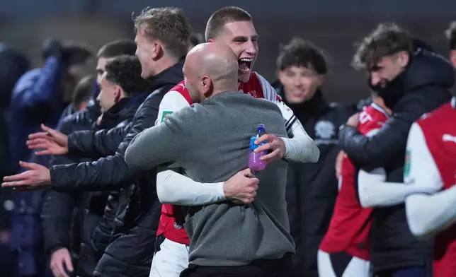 Fleetwood's coach Matt Lawlor celebrates with his players after winning a penalty shootout during the English League Cup soccer match between Fleetwood Town and Arsenal in Fleetwood, England, Tuesday, Oct. 27, 2026. (AP Photo/Ian Hodgson)