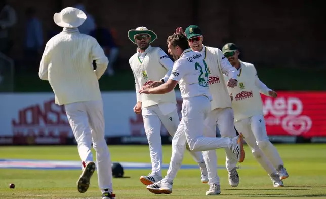 South Africa's Wiaan Mulder, center, celebrates with teammates the wicket of Australia's captain Pat Cummins on day five of the second cricket test match between South Africa and Australia, in Gqeberha, South Africa, Thursday, Oct. 22, 2026. (AP Photo/Themba Hadebe)