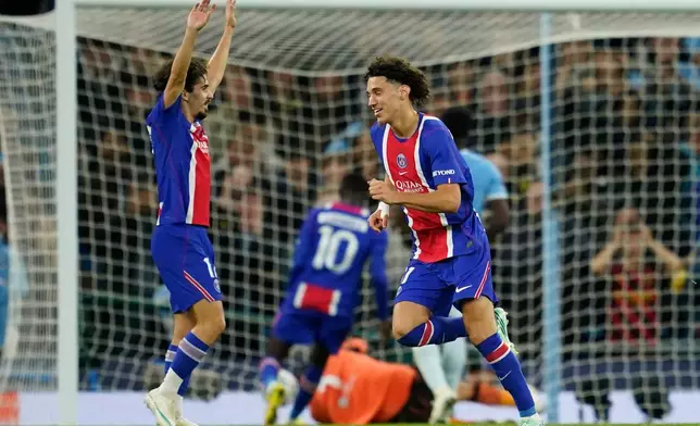 PSG's Maghnes Akliouche, center, celebrates after scoring his side's fourth goal during the Champions League opening phase soccer match between Manchester City and Paris Saint-Germain in Manchester, England, Wednesday, Oct. 14, 2026. (AP Photo/Dave Thompson)