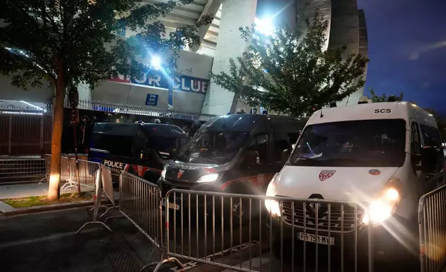 Police vehicles are parked outside the stadium ahead of the Champions League opening phase soccer match between Paris Saint-Germain and FC Barcelona in Paris, Tuesday, Oct. 20, 2026. (AP Photo/Teresa Suarez)